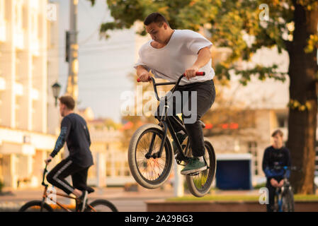 Le mec réalise un stunt sur BMX, sautant du parapet. Banque D'Images