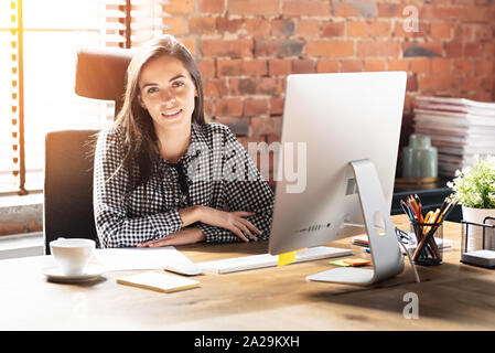 Femme travaillant avec l'ordinateur de bureau à bureau. Souriante jeune employé portrait d'affaires. Banque D'Images