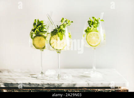 Hugo vin pétillant cocktail à la menthe fraîche et de la chaux dans des verres avec des pailles plus respectueux de l'environnement de travail en marbre blanc, selective focus. Rempli de Banque D'Images