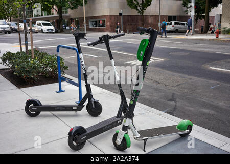 Portland, OR, USA - Sep 13, 2019 : marque d'oiseaux et de chaux dockless marque scooters électriques sont partagés vu garé ensemble sur trottoir au centre-ville. Banque D'Images