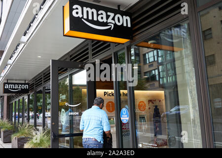 Portland, Oregon, USA - Sep 13, 2019 : Un homme entre dans un casier du moyeu Amazon emplacement, un libre-service place pour enlèvement et retour Amazon paquets. Banque D'Images