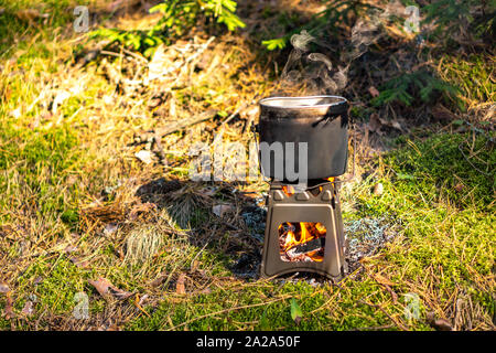 Pot sur bouillante wood burning stove brindille en plein air Banque D'Images