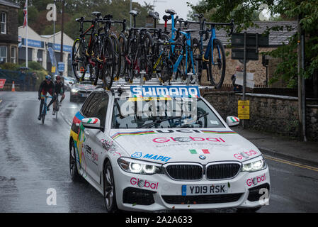 Les Championnats du Monde Route UCI 2019 Mens Elite Road Race, de Leeds à Harrogate 261.8Km sur un parcours difficile par temps humide. On voit ici la course entrant Skipton, Yorkshire, avec l'un des nombreux véhicules de soutien à la suite. Crédit : Stephen Bell/Alamy Banque D'Images