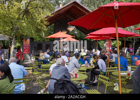 Les gens qui apprécient la nourriture et la musique live dans un coin salon extérieur au marché agricole du samedi à Lake Oswego, Oregon, le 14 septembre 2019. Banque D'Images