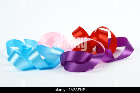 Bleu, rose, rouge et violet satin Rubans torsadés sur fond blanc, Close up Banque D'Images