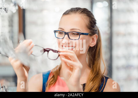 Femme être satisfaits des nouvelles lunettes qu'elle a acheté dans le magasin Banque D'Images