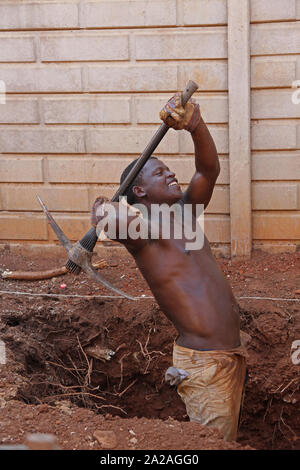 Travailleur de la Construction avec pioche creuser un trou pour une petite piscine, Moreleta Park, Pretoria, Gauteng, Afrique du Sud. Banque D'Images