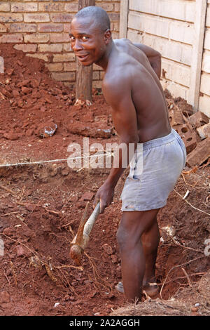 Travailleur de la Construction avec pioche creuser un trou pour une petite piscine, Moreleta Park, Pretoria, Gauteng, Afrique du Sud. Banque D'Images