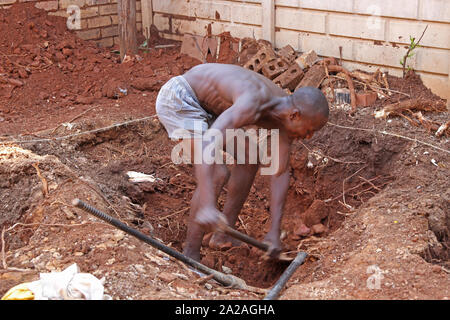 Travailleur de la Construction avec pioche creuser un trou pour une petite piscine, Moreleta Park, Pretoria, Gauteng, Afrique du Sud. Banque D'Images