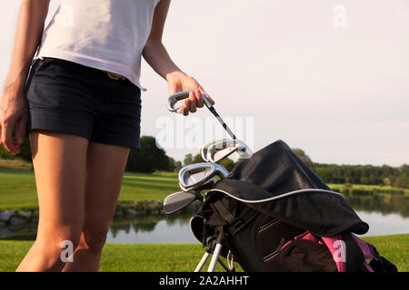 Fille de fer golfeur mise hors sac de golf. Banque D'Images