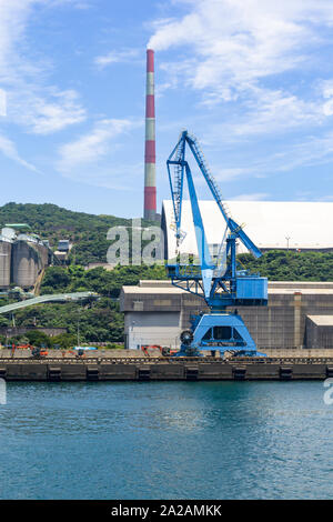 Port avec grande grue, cheminée et bâtiments industriels ; Saganoseki, Kyushu, Japon Banque D'Images