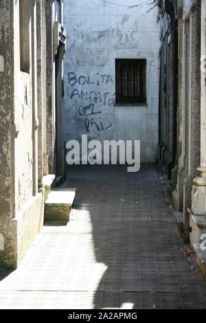 Cimetière de la Recoleta, Buenos Aires. L'écriture désobligeants sur un mur dans le cimetière de Recoleta expatriés invitant à rentrer à la maison. Banque D'Images