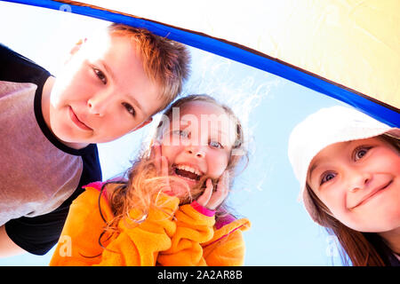 Groupe de trois professionnels, les enfants surpris en regardant le spectateur. Banque D'Images