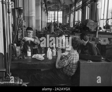 Les travailleurs de l'industrie au cours d'une pause dans un hall d'usine. Banque D'Images