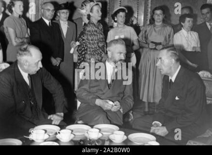 L'Académie des beaux-arts a organisé une réception en l'honneur de l'écrivain Thomas Mann Karl-Palais dans le Prince. La photo montre Thomas Mann (à droite) en conversation avec le ministre de la Culture Dr. med. Alois Hundhammer (milieu) et le maire Thomas Wimmer (à gauche). Banque D'Images