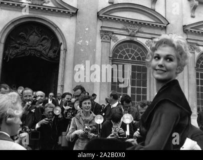 En juin 1959, Kim Novak a visité le Château de Schleissheim à Munich. C'était une sorte d'événement PR, au cours de laquelle de nombreux représentants de l'industrie du film et du cinéma ainsi que des dizaines de journalistes ont été invités. La photo montre Kim Novak équitation dans un chariot vers le château. Elle est entourée par de nombreux fans et les photographes. Banque D'Images