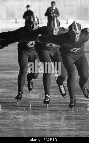 Aux Jeux Olympiques d'hiver de 1956 à Cortina d'Ampezzo les compétitions de patinage de vitesse ont été société heldon le lac gelé Misurina. La photo montre probablement trois athlètes canadiens pendant leur formation s'exécute. Banque D'Images