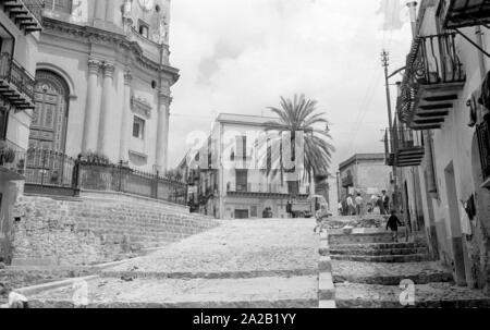 Une photo plus grande rue à Montelepre. Sur la gauche, l'église de Maria Santissima del Rosario, construit au 15ème siècle. Montelepre dans la province de Palerme (Sicile) est à 26 km seulement de la ville de Palerme. Ancien héros folklorique sicilien Salvatore Giuliano est né à Montelepre en 1922, et il est enterré dans le cimetière (Ostfriedhof) de la ville. Les habitants de Montelepre vivent principalement de l'agriculture. Banque D'Images