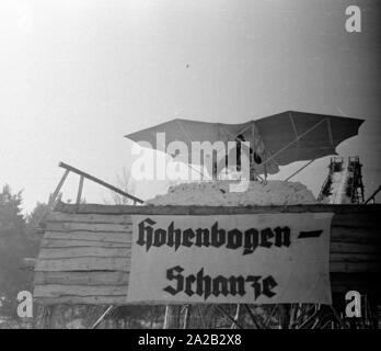 La photo montre le hobby-bricoleur Hans Frank avec sa construction qui ressemble à un traîneau "volants". Apparemment il voulait essayer sa construction à l'Hohenbogen ski jump près de Neukirchen. Saut de ski a été construite en 1952, mais à partir 1959 pas de concours périodiques ont eu lieu et le ski jump a été démolie dans les années 1960. Banque D'Images