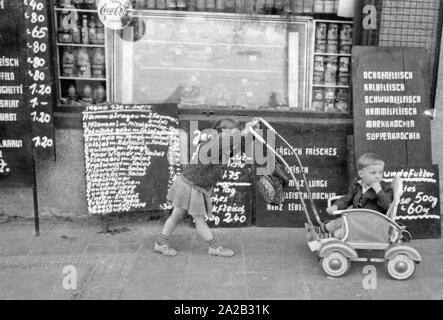 Vue de la rue Leopoldstrasse à Munich. La photo montre deux enfants en attente devant une boucherie. Banque D'Images