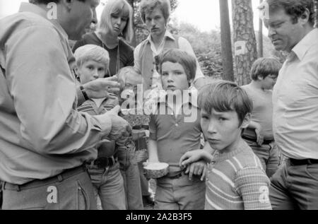 Une journée de la forêt a été organisée pour les enfants handicapés avec une excursion à la forêt bavaroise à proximité de Kelheim. La photo montre un forestier, qui donne à l'arbre pour enfants différents disques touchez et regardez. Banque D'Images