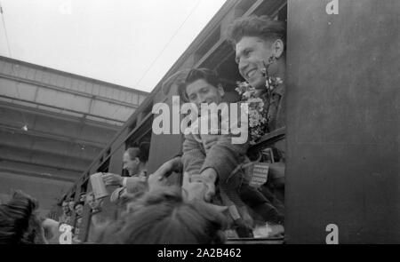 La photo montre probablement membres de l'expédition dans l'Himalaya à la large pic entre août et décembre 1954. Le voyage pour la région himalayenne explique le jour de départ le 28 avril. Les alpinistes participantes disent au revoir à leurs proches et les parties intéressées à la gare principale de Munich. Ils vague à la population sur la plate-forme des fenêtres des wagons. Banque D'Images