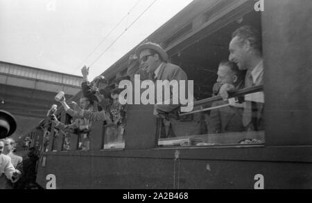 La photo montre probablement membres de l'expédition dans l'Himalaya à la large pic entre août et décembre 1954. Le voyage pour la région himalayenne explique le jour de départ le 28 avril. Les alpinistes participantes disent au revoir à leurs proches et les parties intéressées à la gare principale de Munich. Ils vague à la population sur la plate-forme des fenêtres des wagons. Banque D'Images