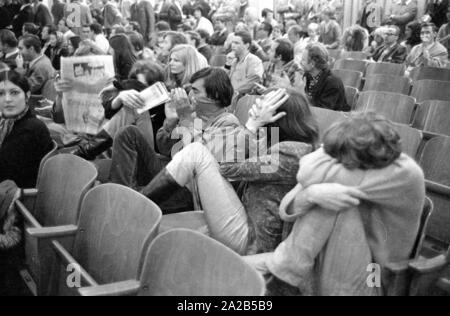 Les membres de l'Opposition Ausserparlamentarische Opposition extra-parlementaire (APO) a obtenu l'accès à une campagne électorale de la CSU avec de faux billets dans l'Bayernhalle à Munich. Photo des membres de l'APO couvrant leurs visages dans le public à un événement de la CSU. Banque D'Images