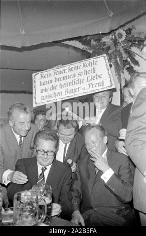 À l'occasion de l'Oktoberfest en 1970 Willy Brandt était un invité dans le chapiteau de l'Fischer-Vroni. La photo le montre avec Hans-Jochen VOGEL (à gauche), le maire de Munich. Dans l'arrière-plan une personne est titulaire d'un panneau avec un drôle de dire. Banque D'Images