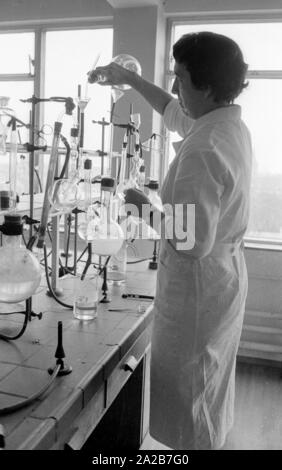 Une femme effectue des expériences chimiques dans un laboratoire dans le cadre de l'comparisona pain physiologique nutritionnel de l'Institut Max Planck à Dortmund. L'étude a été publié en 1961 par le professeur dr. Hans Glatzel et dr. Helmut Canzler clinique du ministère de l'physiologiques Institut Max Planck de physiologie nutritionnelle dans la région de Dortmund. Banque D'Images