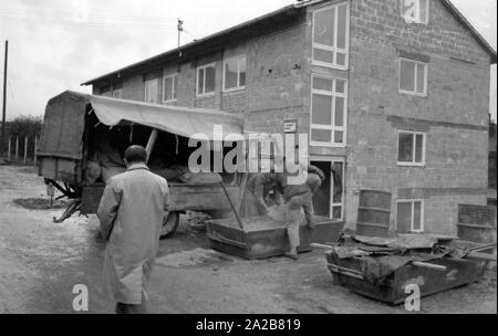 Deux travailleurs de la construction ciment mélange sur le site de construction d'un bâtiment résidentiel neuf en 038884. Banque D'Images