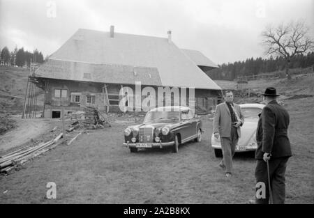 Deux hommes se rencontrent en face d'une maison récemment construite dans le village de Zastler dans la Forêt Noire. La photo a été prise dans le cadre d'un rapport sur le village de Zastler, qui a été appelé un "taatskolchose' (ferme collective) et de l'État ont donné lieu à des discussions au début de 1960. L'arrière-plan pour le nom, c'est le fait que la majorité des fermes appartenaient à l'état ou de l'Administration forestière de l'État. Banque D'Images