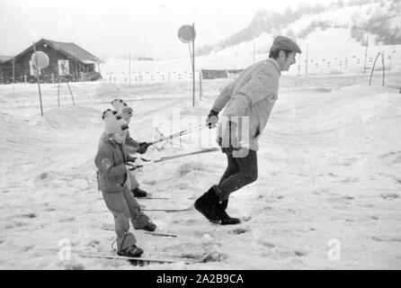 Les enfants à un cours de ski de l'Skischule Garmisch-partenkirchen. L'entreprise "marqueur" annonce ses fixations de ski de sécurité avec des bannières. Banque D'Images