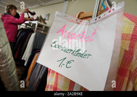 Greifswald, Allemagne. 06Th Oct, 2019. Un panneau avec les mots "ommerkleider 1,- Euro" se bloque sur un porte manteau dans l'Sozialkaufhaus Greifswald. L'institution propose des meubles d'occasion, appareils électriques, l'habillement, des chaussures ou des livres à vendre aux citoyens. Credit : Stefan Sauer/dpa-Zentralbild/dpa/Alamy Live News Banque D'Images