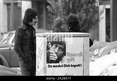 Les jeunes dans le quartier Schwabing de Munich. Dans l'avant-plan est une affiche de la police, qui met en garde contre l'usage d'un médicament : 'Les stupéfiants, vous détruire vous-même ! Le concessionnaire fait banque.' Banque D'Images