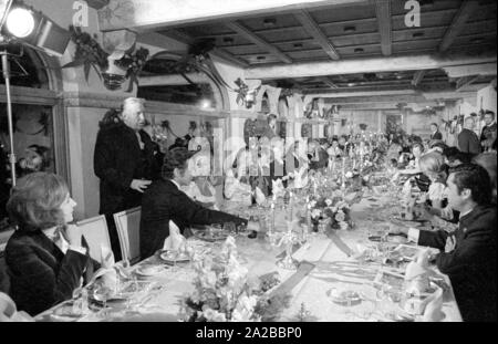 En 1971 un festival de chasse a eu lieu à Schloss Fuschl à Hof bei Salzburg. Le bateau pavillon de chasse du 15ème siècle est un lieu de rencontre pour des invités de partout dans le monde. Dans l'image : le propriétaire de l'hôtel et l'hôte de la chasse, Carl Vogel (debout, à droite de la photo), s'occupe de la partie de dîner. Banque D'Images