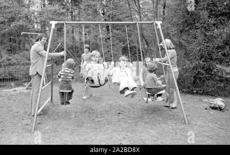 Accueil Histoire avec la famille Beckenbauer. Sur la photo : le couple Beckenbauer et les enfants sur la balançoire dans le jardin. Banque D'Images