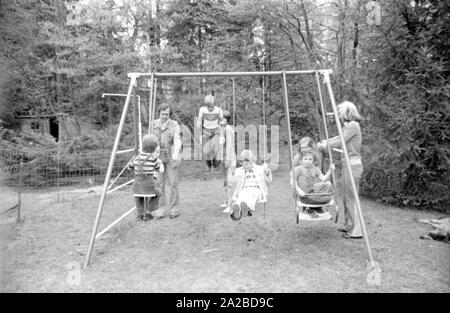 Accueil Histoire avec la famille Beckenbauer. Sur la photo : le couple Beckenbauer et les enfants sur la balançoire dans le jardin. Banque D'Images