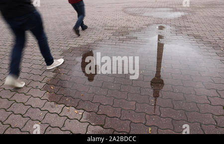 Berlin, Allemagne. 09Th Oct, 2019. La tour de télévision et les piétons se reflètent dans une flaque d'eau de pluie. Credit : Jörg Carstensen/dpa/Alamy Live News Banque D'Images