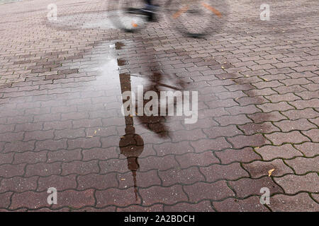 Berlin, Allemagne. 09Th Oct, 2019. Une flaque de pluie reflète la tour de la télévision et d'un cycliste. Credit : Jörg Carstensen/dpa/Alamy Live News Banque D'Images
