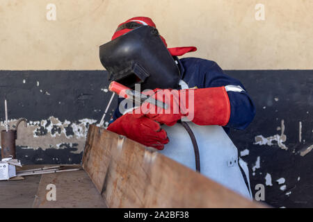 Soudeur Motswana travailleur dans un atelier de soudage, le Botswana deux pièces de métal Banque D'Images