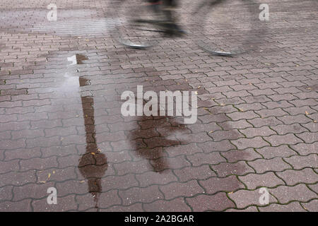 Berlin, Allemagne. 09Th Oct, 2019. La tour de télévision et les piétons se reflètent dans une flaque d'eau de pluie. Credit : Jörg Carstensen/dpa/Alamy Live News Banque D'Images