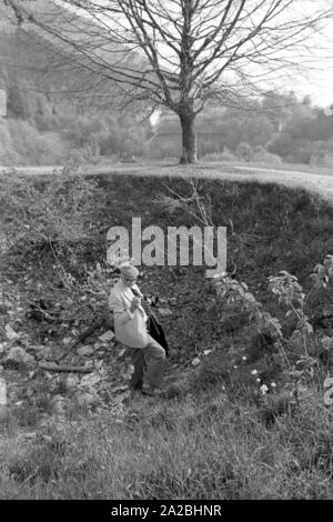 Un touriste explore un cratère de bombe sur l'Obersalzberg. L'Obersalzberg a été bombardé le 25.04.1945. Banque D'Images