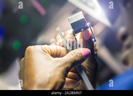 Le Botswana, femme africaine dans une usine de diamants contrôle de qualité d'un diamant poli récemment. Banque D'Images