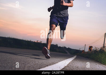 Coureur athlète pieds d'exécution sur la route, le jogging à l'extérieur concept. Homme qui court pour faire de l'exercice. Banque D'Images