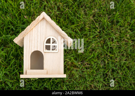 Mise à plat de la petite maison de bois sur l'herbe verte Banque D'Images