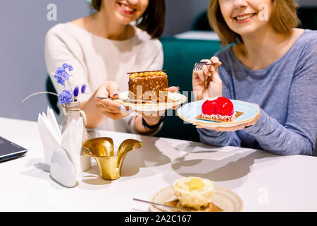 Deux jeunes jolies amies s'amuser et manger des desserts à la pâtisserie ou boulangerie Banque D'Images