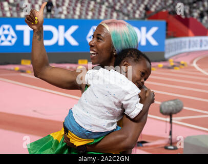 SHELLY-ANN FRASER-PRYCE (JAM) (G) célèbre avec le drapeau et son fils Zyon après sa 1ère place au 100m le jour 3 de l'IAAF Championnats du monde d'athlétisme à Doha, QATAR Banque D'Images