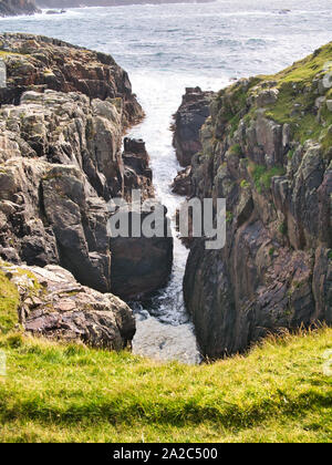 Un petit geo, ou Inlet, près de Culswick Broch sur l'ouest de Mainland Shetland, UK. Le soubassement est Pluton Sandsting - roche ignée Microgranite - Banque D'Images