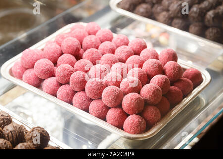 Boules au chocolat avec glaçage rose. Vitrine de bonbons à Banque D'Images